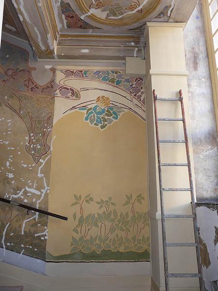 Restauration des peintures de la cage d'escalier, essai sur un mur latéral.