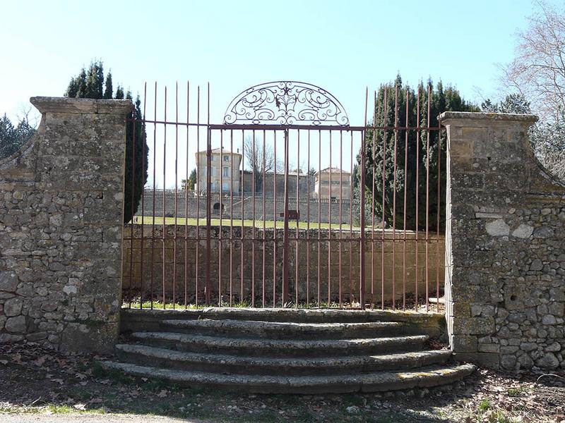 Portail Est du parc clos de murs, en bordure de la route, vue de face avec le château.