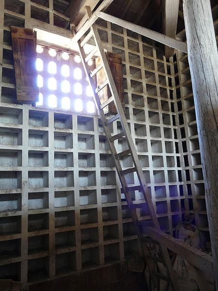 Pavillon Nord-Est, intérieur du pigeonnier, boulins et échelle tournante.