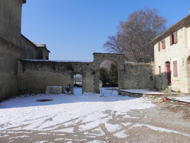 Mur de clôture et porte charretière fermant la cour à l'est.