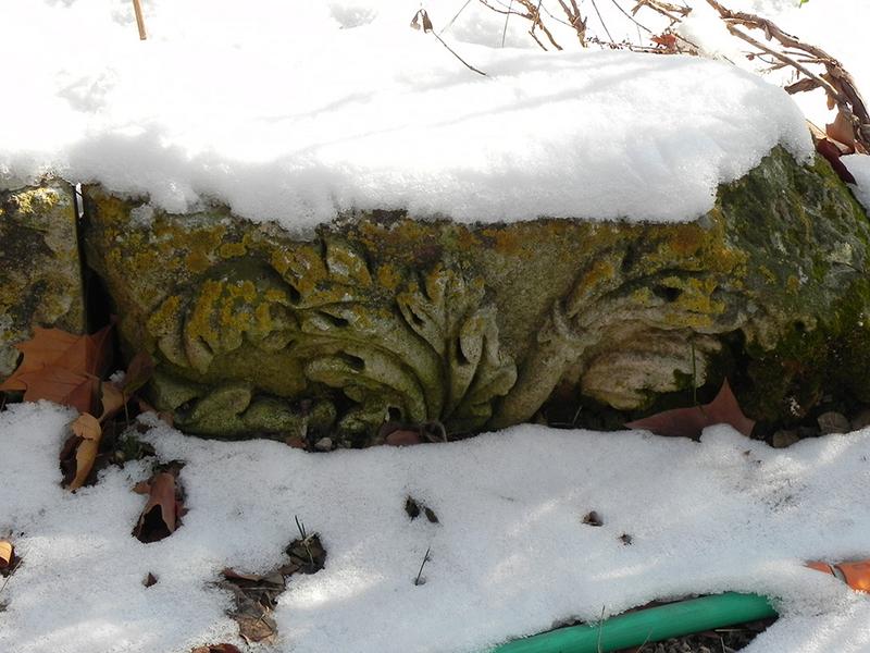 Dépôt lapidaire dans le jardin : clé du vestige de la plate-bande.