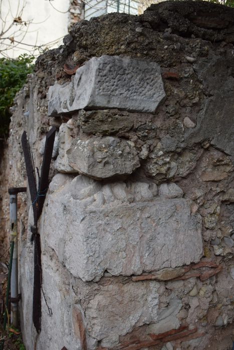 jardin, détail d’un élément en remploi dans le mur