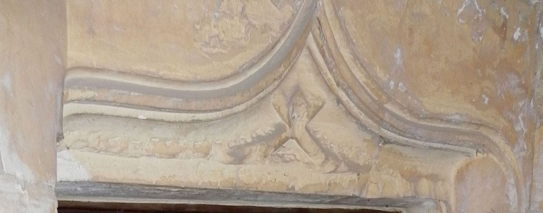 escalier à vis, détail d’un linteau de porte sculpté d’une croix de saint André