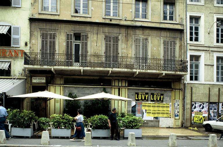 Vue générale de la façade sur le cours, les baies étant bouchées par des parpaings.