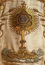 bannière de procession : Venite Adoremus, détail de la devise de la ville