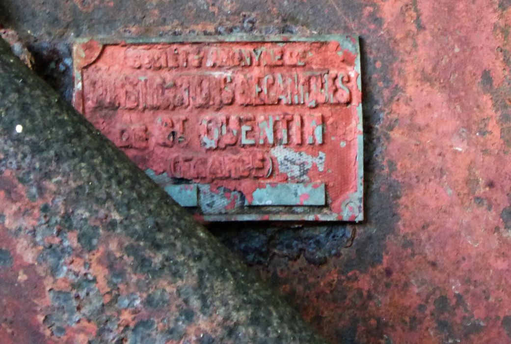 Machine à pomper dite pompe à vapeur Burton n°10696. Plaque signalétique : « Société anonyme / constructions mécaniques / de St-Quentin / (France) » sur le bâche alimentaire et ventilateur entre les deux chaudières.