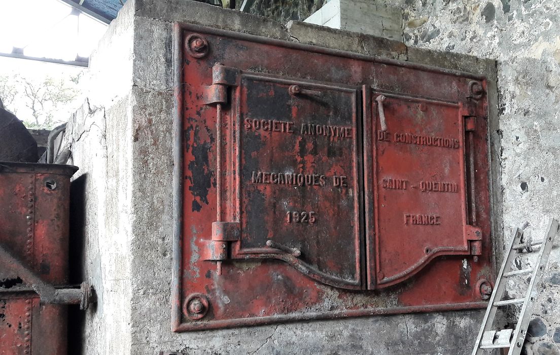 Ensemble de deux chaudières à vapeur. Chaudière 1. Face arrière, porte à deux vantaux ouvrant sur la chaudière à tubes de fumées. Inscription : « Société anonyme / de constructions / mécaniques de / Saint-Quentin / 1925 / France ».