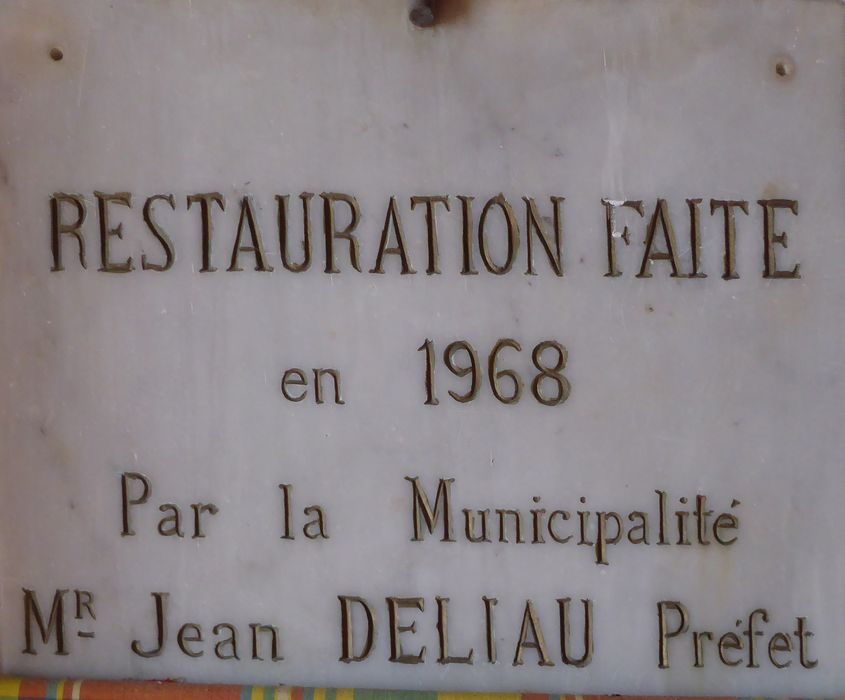 Bas-côté sud, inscription sur une plaque de marbre : « RESTAURATION FAITE / en 1968 / Par la Municipalité / Mr Jean DELIAU Préfet »