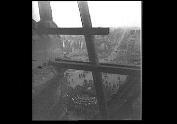 Concert sur le parvis, à l'arrière plan, Reims en ruines, vue du haut de la tour est du bras sud du transept